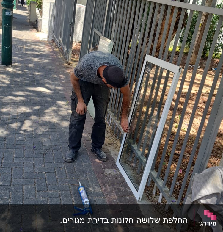 אדם מתקין מסגרת אלומיניום על גדר